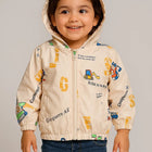 Child wearing a beige jacket with colorful graphics and text 