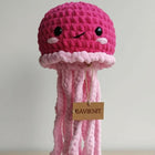 Pink crochet jellyfish toy with a visible brand tag on a light background