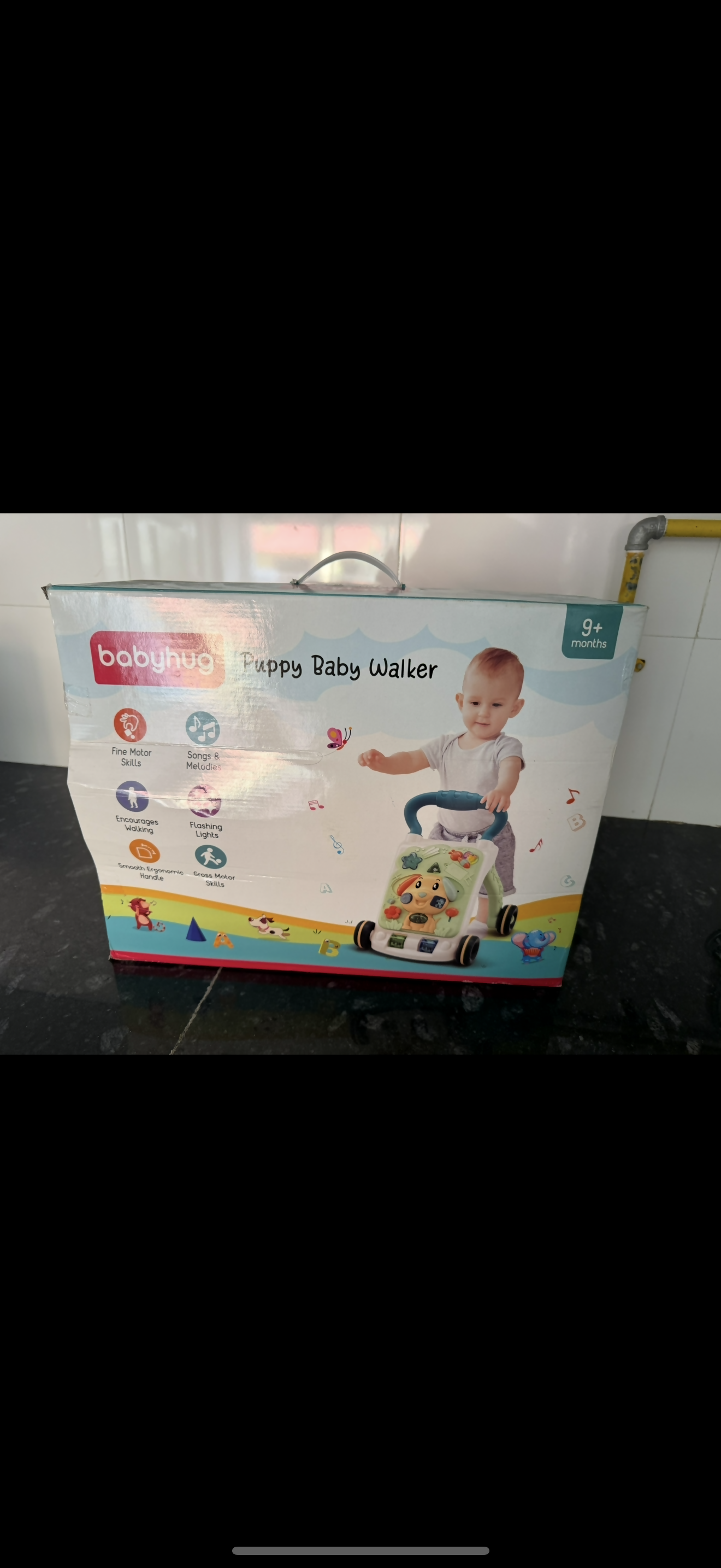 Baby walker with packaging on a dark surface