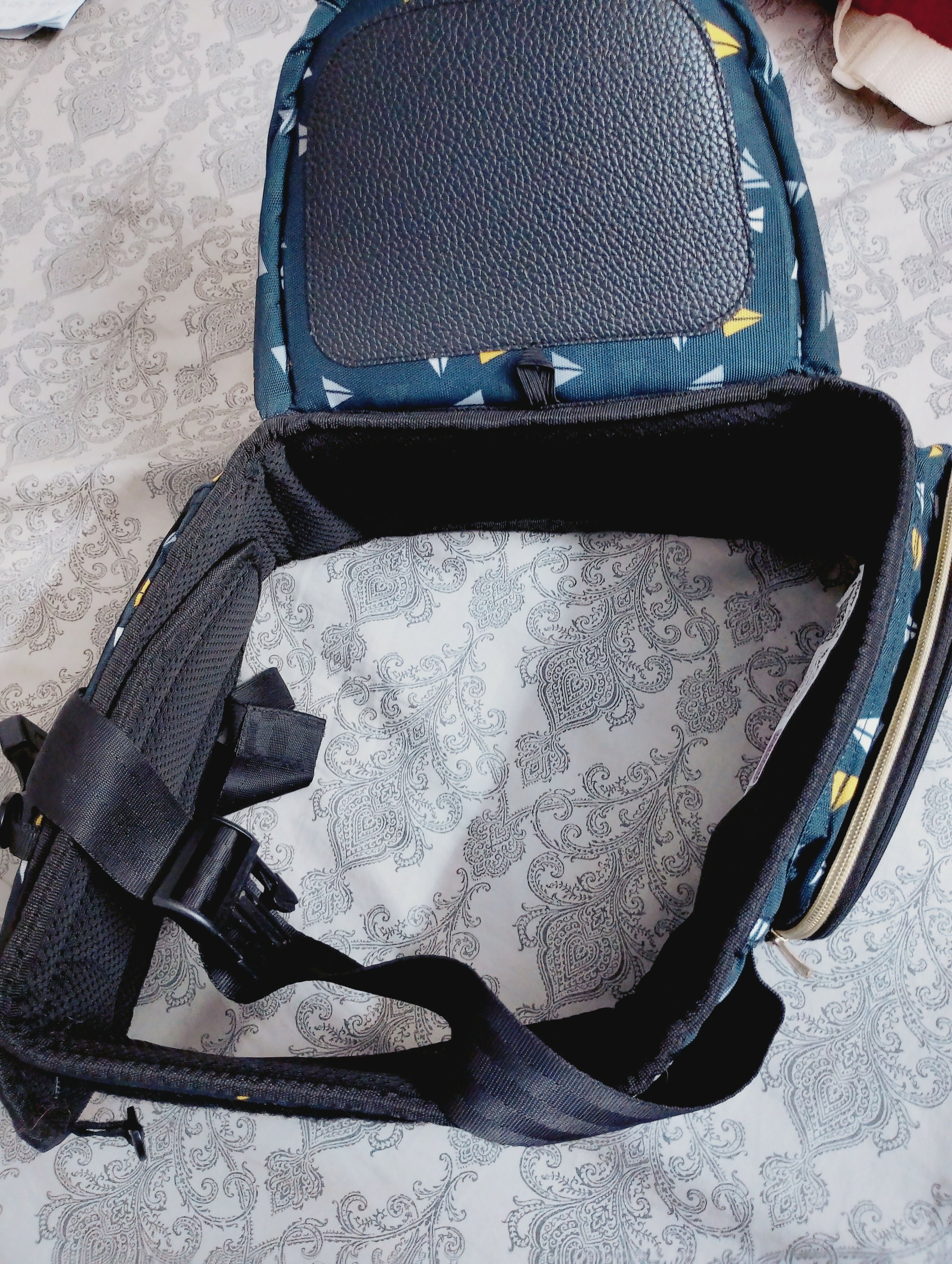 Close-up of a baby carrier with a floral pattern on a textured surface