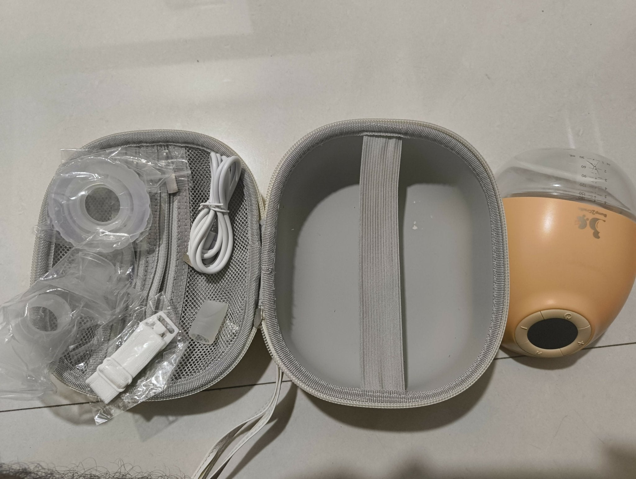 Bump2Cradle Wearable Hands-Free Breast Pump with travel case, featuring a hands-free wearable design, adjustable suction levels, rechargeable battery, quiet operation, and BPA-free components. Like new, barely used.