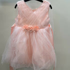 Pink dress with floral embellishments on a hanger against a plain background