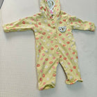 Yellow baby onesie with floral pattern on a textured surface