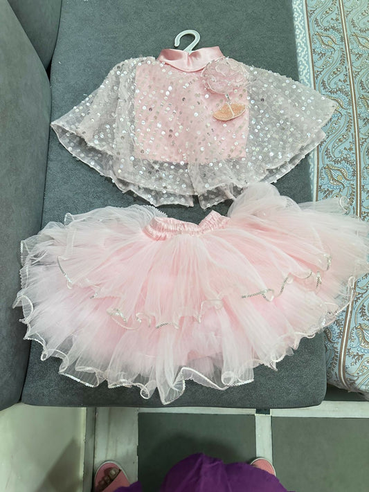 Pink and white dress with a sheer overlay on a gray surface