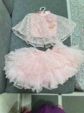 Pink and white dress with a sheer overlay on a gray surface