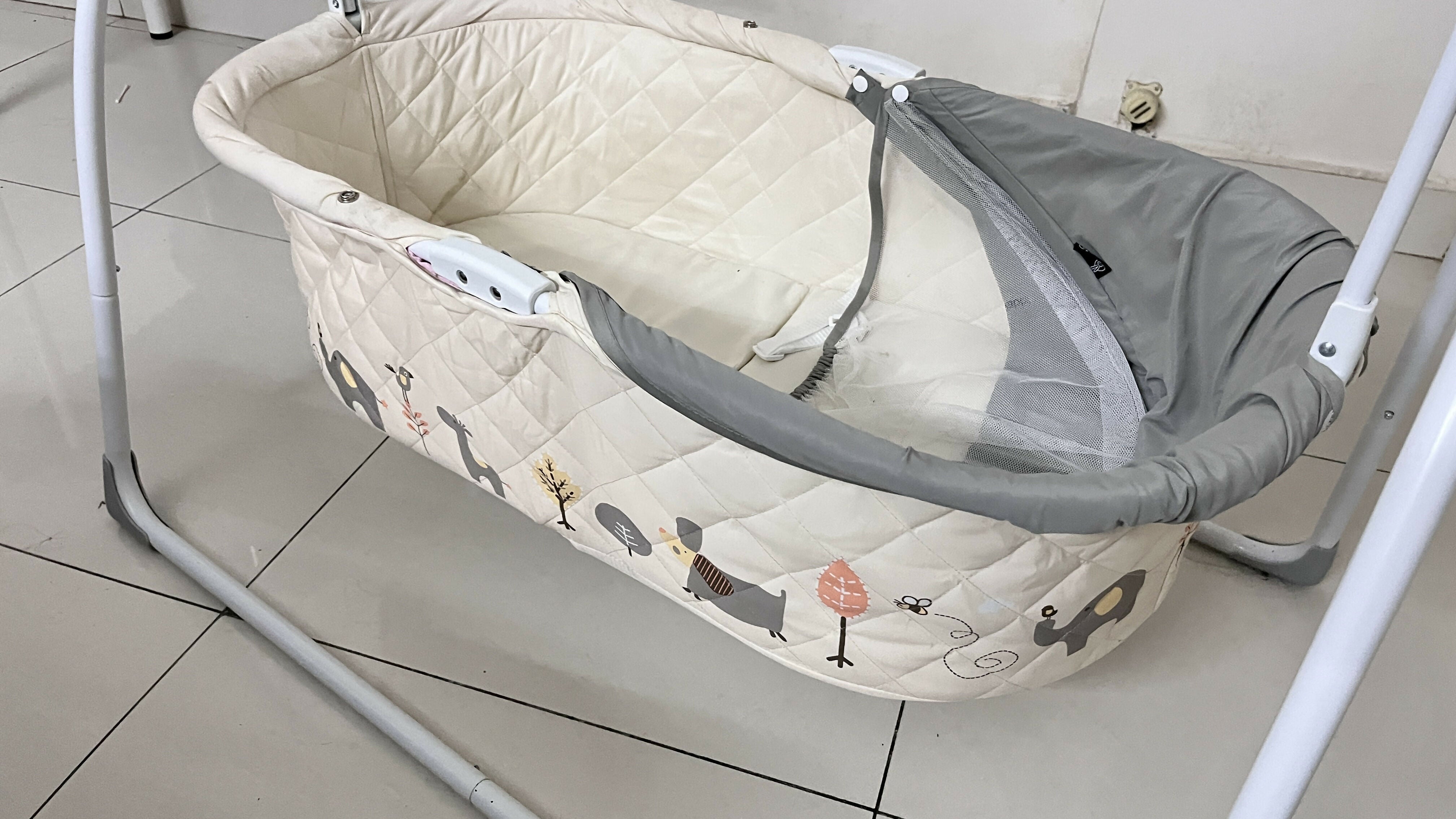 Baby crib with a quilted cover on a tiled floor