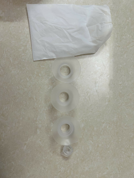 Three clear plastic washers on a textured surface with a white paper towel in the background.