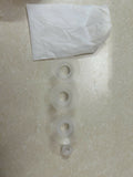 Three clear plastic washers on a textured surface with a white paper towel in the background.