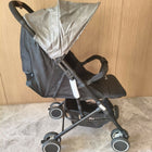 Black stroller with a beige canopy 