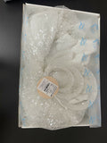 White sequin dress in a clear plastic bag on a black background