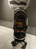 Stroller with colorful patterned mat on a tiled floor