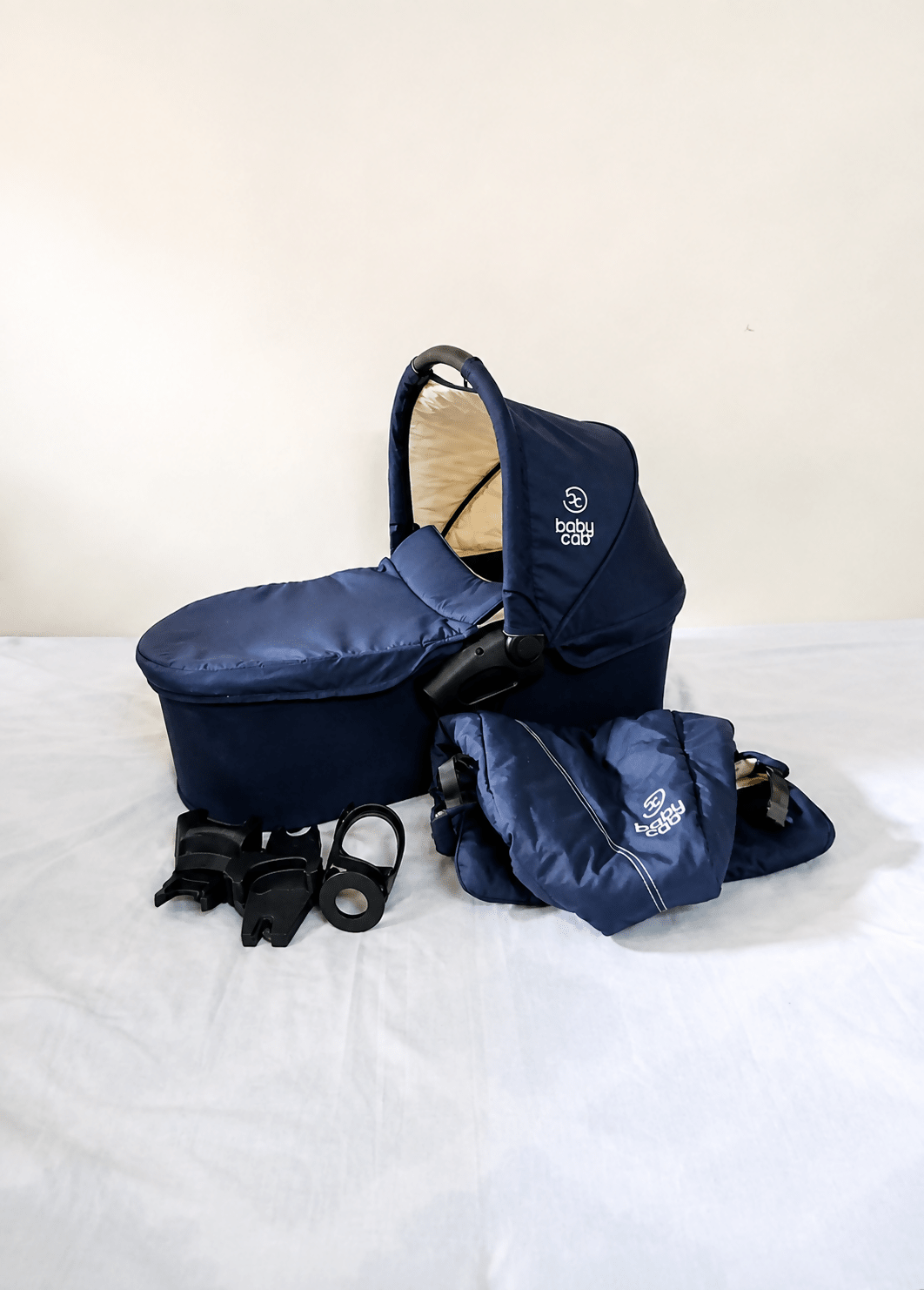 babycab Noah Carrycot Bassinet in Navy Blue, designed as a stroller attachment with a comfortable padded interior, protective canopy, sturdy construction, and cozy lie-flat space for newborns and young infants.