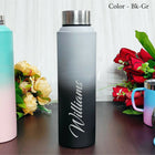Gradient water bottle with 'Williams' engraving on a wooden surface with flowers in the background.