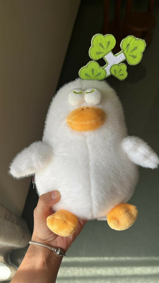 Plush toy penguin held by a hand with a blurred background