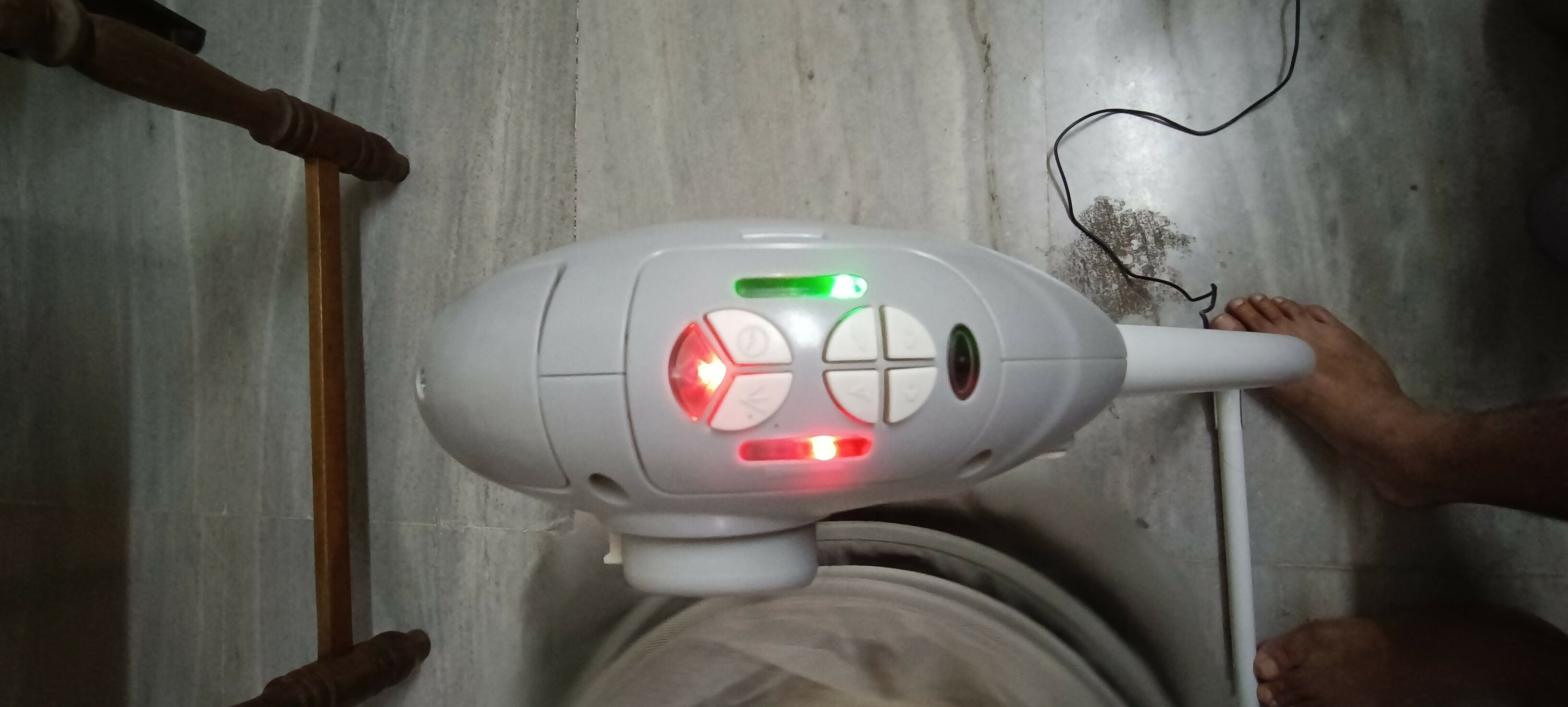 White electronic device with red and green lights on a white wall.