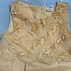 Beige floral embroidered garment on a light blue background
