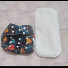 Colorful diaper with space design and white diaper cover on a light pink surface