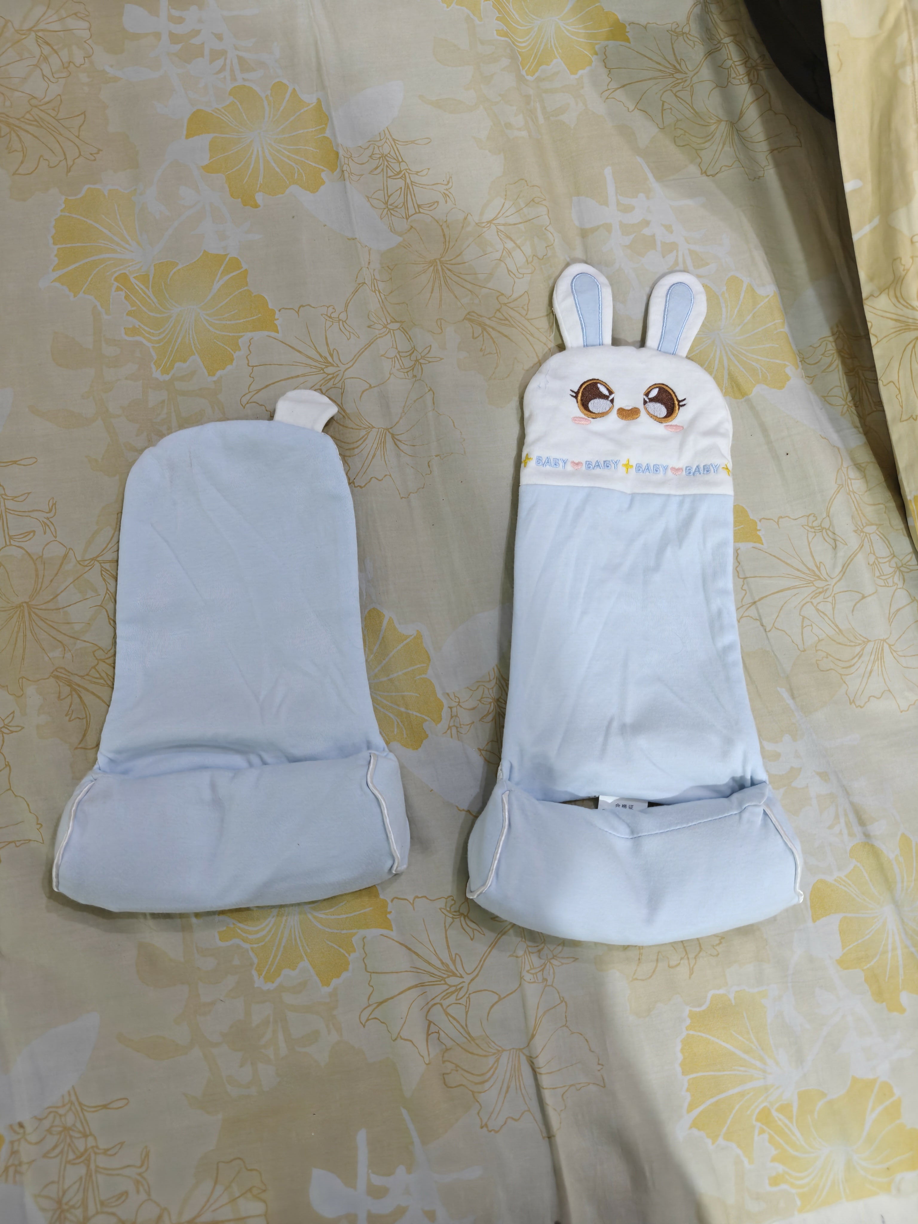 Pair of white gloves with bunny ears on a floral fabric background