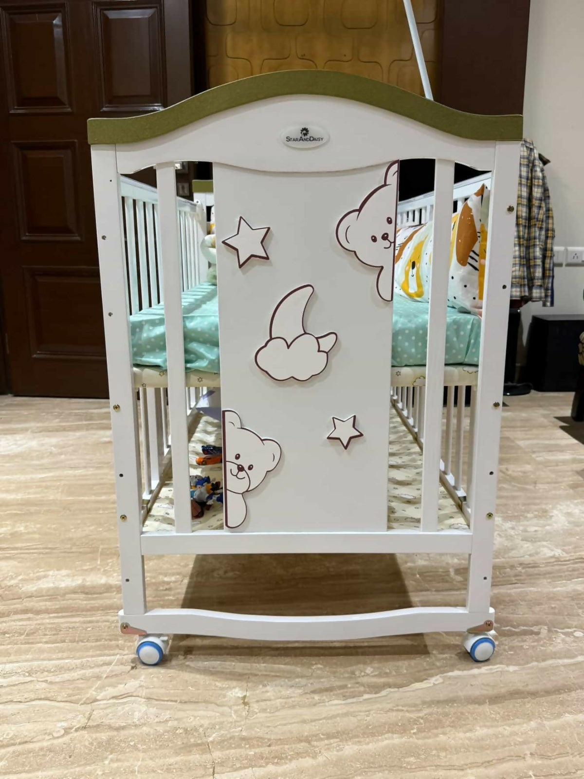 Children's crib with cartoon designs on a wooden floor