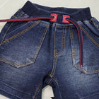 Folded blue jeans with red stitching on a white background