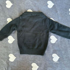 Black sweater on a gray surface with white heart patterns