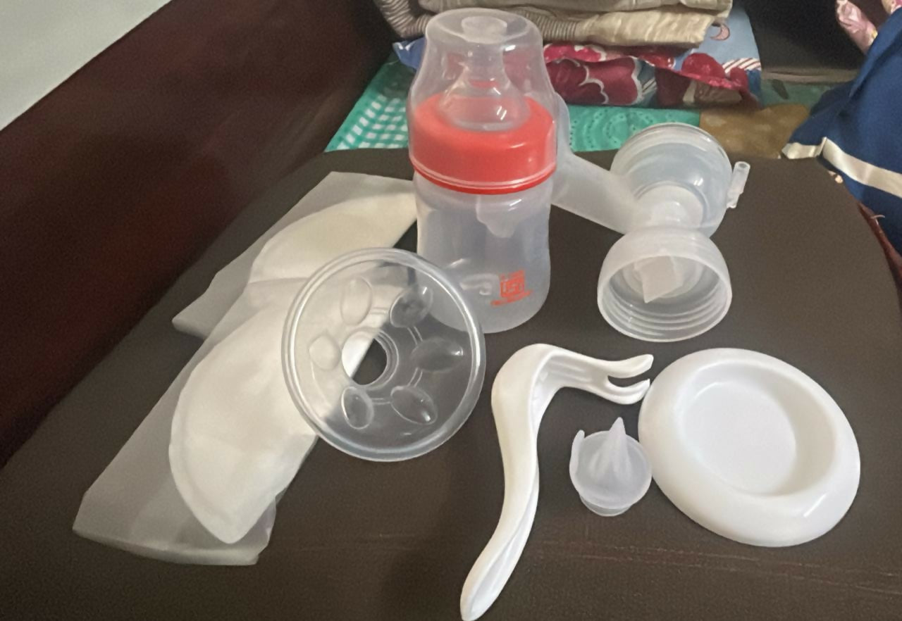 Collection of baby bottle parts on a dark surface