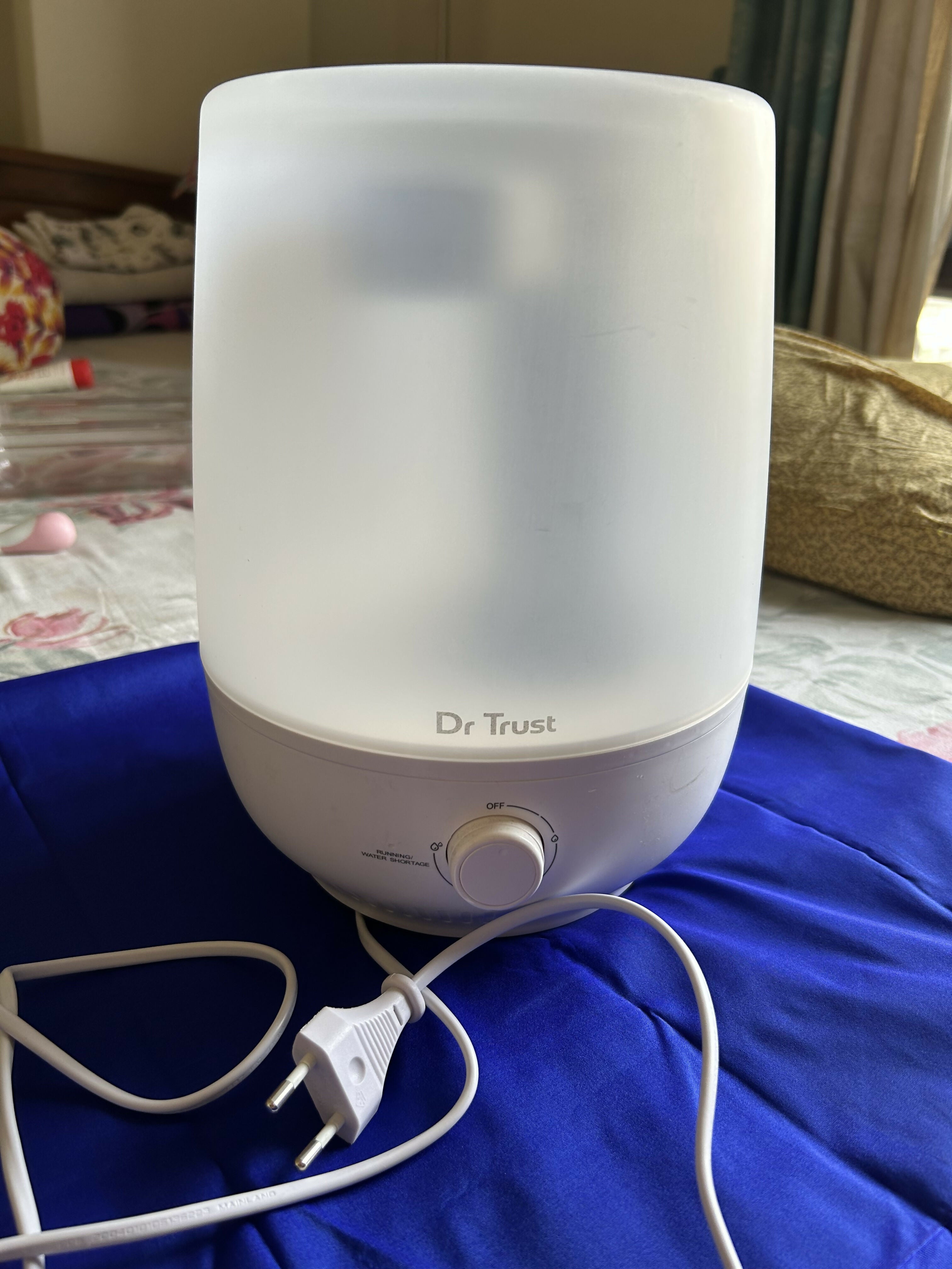 Dr. Trust humidifier on a blue surface with a blurred background