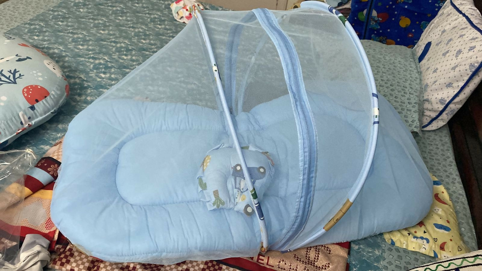 Blue baby crib with canopy on a patterned surface