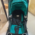 Teal and black stroller on a tiled floor
