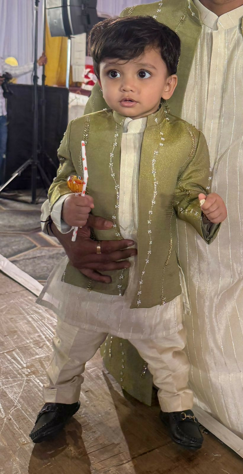 Child in a green and white traditional outfit 