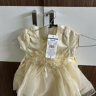 Gold dress on a hanger with a tag 