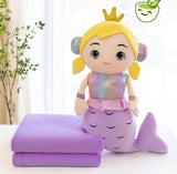 Mermaid-themed plush toy with a purple tail and crown on a white surface.