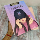 Notebook with a cover featuring an illustration of a person wearing a cap, held by a hand on a wooden surface.