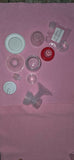 Collection of various plastic bottle caps on a pink surface