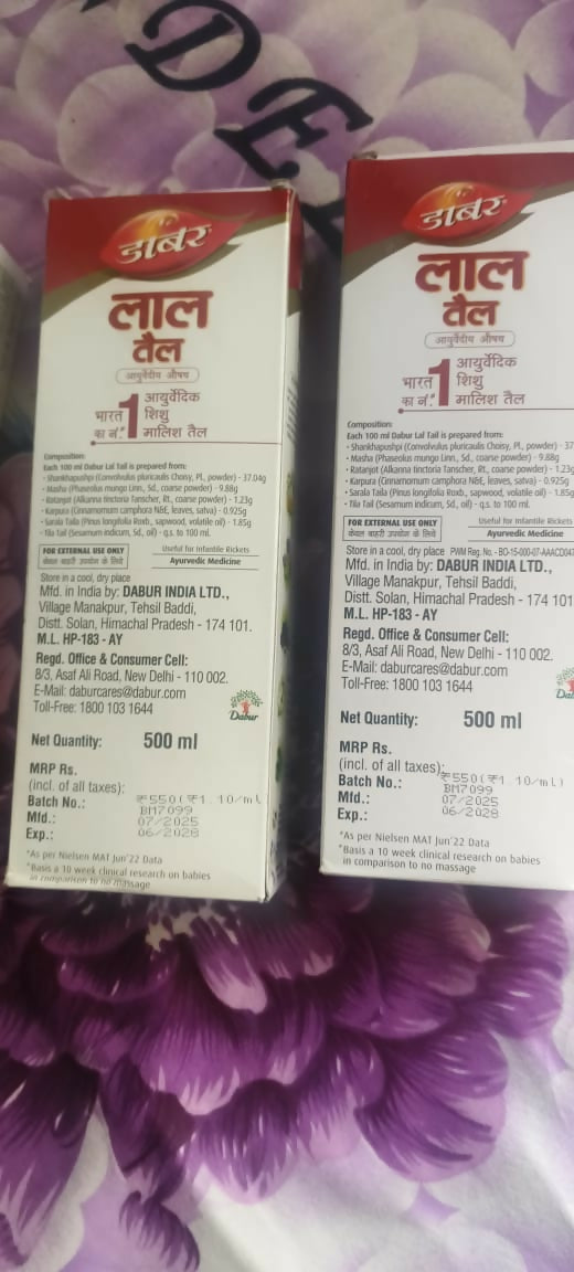 Two bottles of Dabur Vatika hair oil on a purple floral background