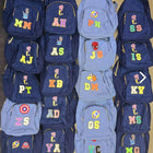 Collection of blue backpacks with colorful letters and symbols on a beige background