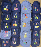 Collection of blue backpacks with colorful letters and symbols on a beige background