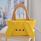 Yellow basket with bunny ears and a face on a chair