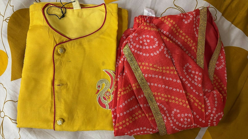 Yellow and red traditional outfit with a patterned fabric on a yellow background