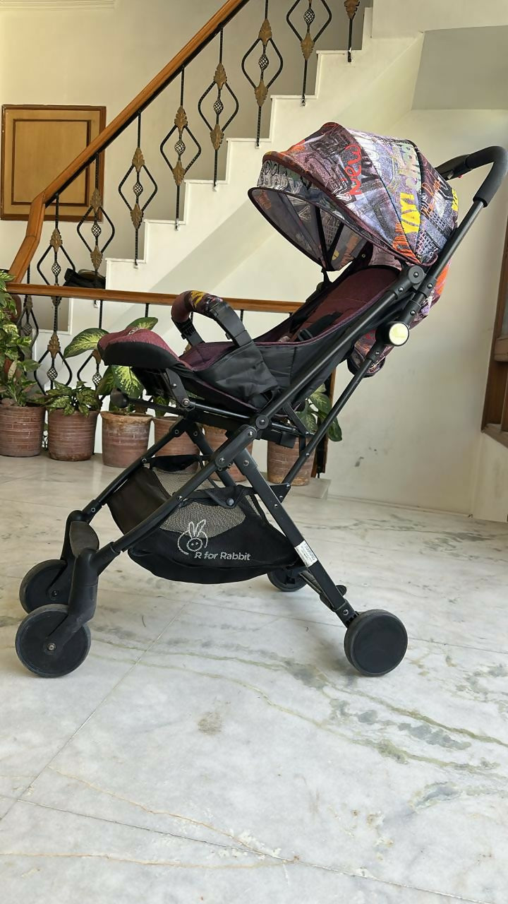 Black stroller with colorful canopy on a marble floor