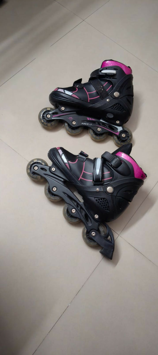 Pair of black and pink inline skates on a tiled floor