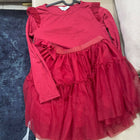 Red dress with ruffled layers on a hanger against a neutral background