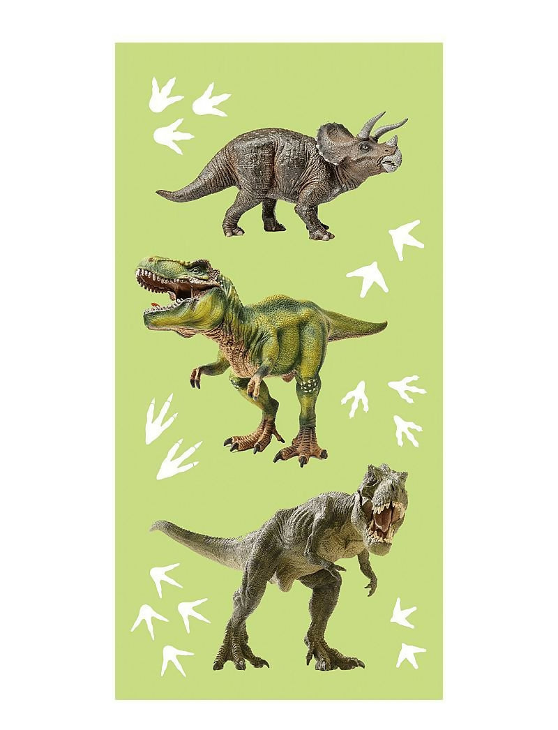 Three toy dinosaurs on a green background 