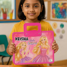 Child holding a pink toy with Barbie design in a classroom setting