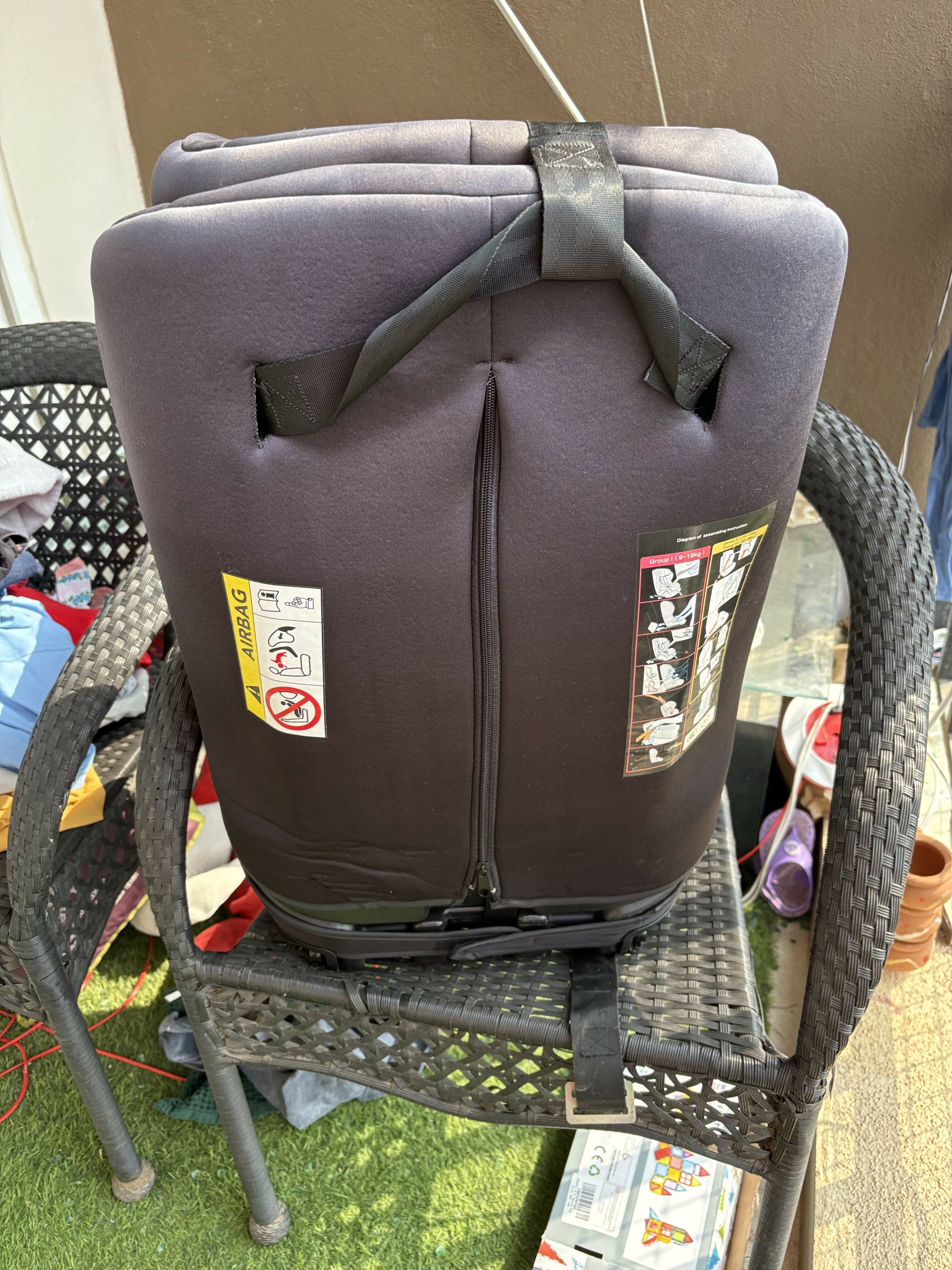 Gray child safety seat on a chair outdoors