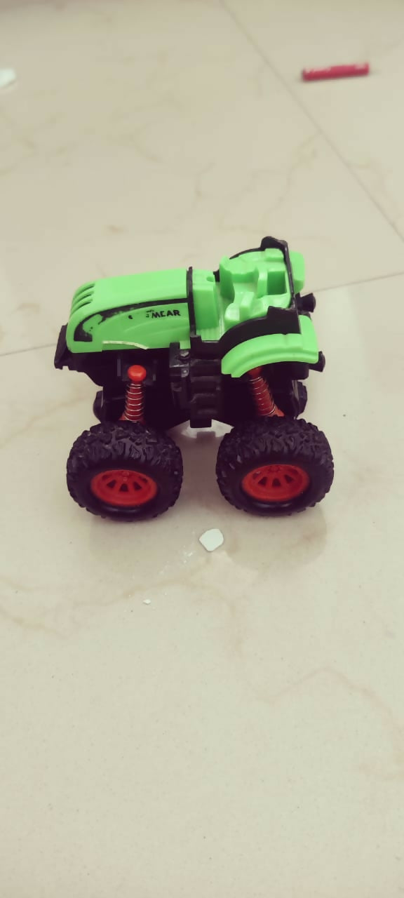 Toy car with green body and black wheels on a light-colored floor.