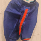 Blue shorts with an orange stripe on a tiled floor