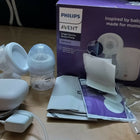 Philips Avent baby bottle and accessories on a wooden floor