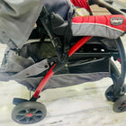 Gray and red stroller with visible brand logo on a light background
