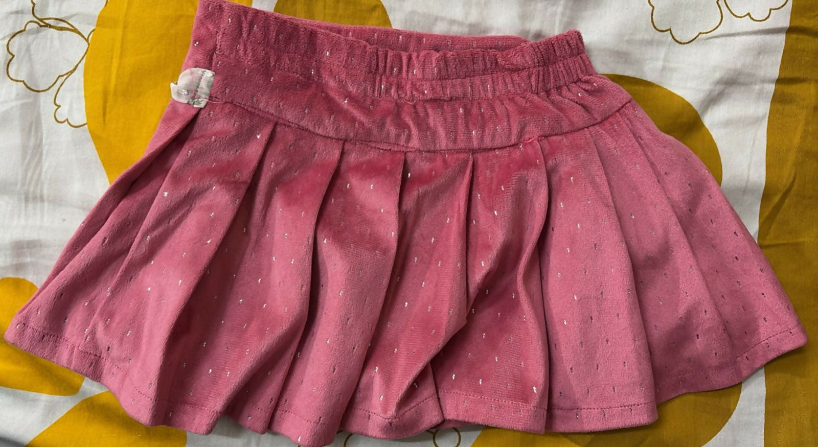Pink skirt with white polka dots on a yellow and white patterned background